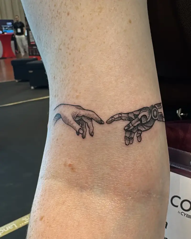 Tattoo zweier sich berührender Hände, Mensch und Maschine, aufgenommen in der Saarlandhalle