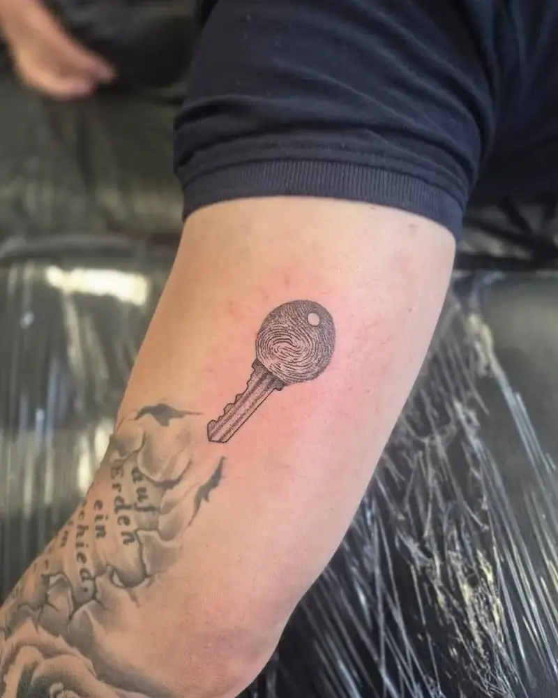 Frisch gestochenes Tattoo: Schlüssel mit Fingerabdruck als Schlüsselkopf